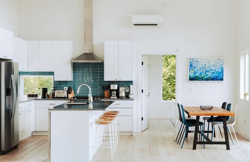 Young Harris Cabin | EcoModMtn is a 3BR/3.5BA luxury retreat with panoramic fall views, floor-to-ceiling windows, a gas fireplace, private hot tub, firepit, and designer kitchen. Perfect for families, couples, or friends seeking cozy mountain elegance this autumn.