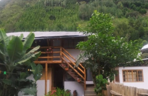 Oxapampa Cottage | Habitacion tipo cabaña con acabados en madera, terraza con vista hacia la montaña