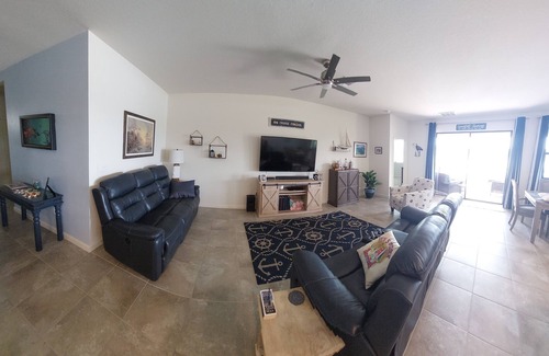 Port Malabar House | Lake view home with a screened outdoor entertainment area.