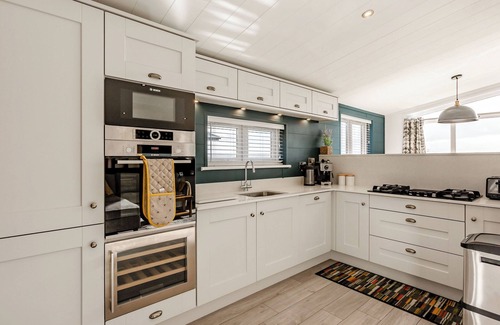 Middlezoy Ski Chalet | Luxurious lodge with vaulted ceilings and a welcoming feature fireplace.