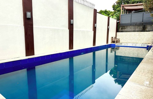 Moonwalk Villa | Minimalist Retreat with a Expansive Turf Garden and Vivid Blue Pool