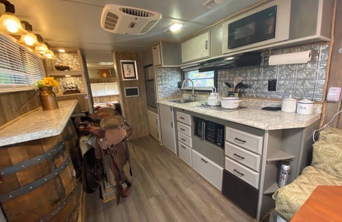 Milton RV Rental | The "Bunkhouse" (western-themed glamper) sleeps 2 to 4 avg size people. There's even a bar with real western saddles for barstools! All new electric appliances, so super-easy to "glamp" in a beautiful, treed area of the park. Access to the park's am
