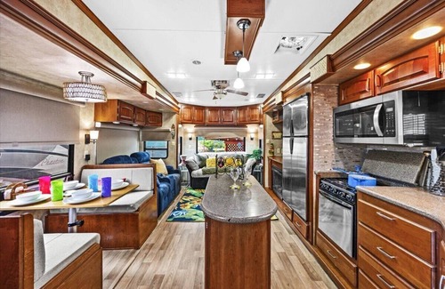 Milton RV Rental | THIS IS AN AWESOME 36' RENTAL CAMPER WITH AMAZING LONG DECK, PLUS A SECOND STEP-DOWN DECK TO YOUR OWN PRIVATE HIDEAWAY TIKI BAR! A BEAUTIFUL HUGE LIVE OAK COVERS THE ENTIRE LOT SO IT'S ALWAYS SHADED, AND THIS EVEN COMES WITH A TABLE & CHAIRS FOR OUT