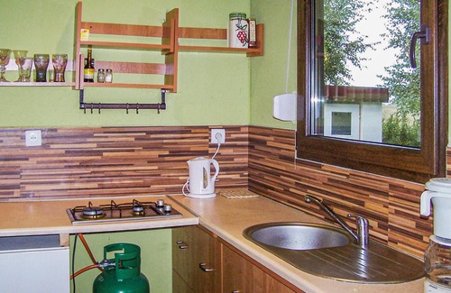 Nowecin House | This small wooden cottage has a covered terrace with garden furniture.
