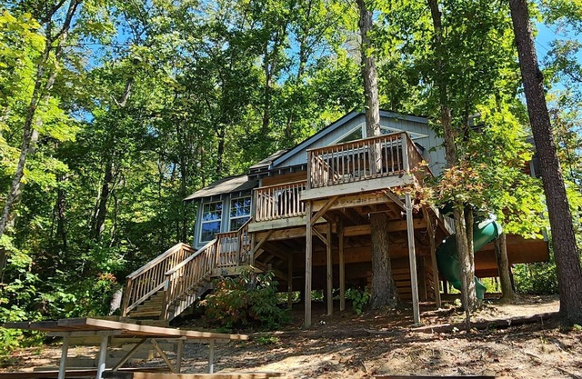 2-story treehouse with a cargo net connecting the upstairs lofts, a large balcony with a slide to the ground level, sleeps 10.