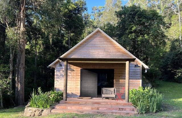 Cedar cabin in serene cool setting in rainforest bush, traditional luxe