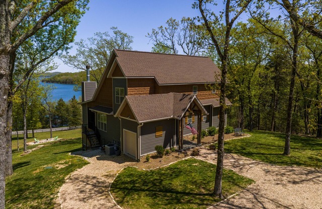 Elegant lakefront home with a fireplace, screened patio & lovely views