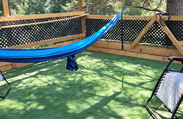 Glamping in the woods with this Treehouse built in between 2 big alive Fir Tree