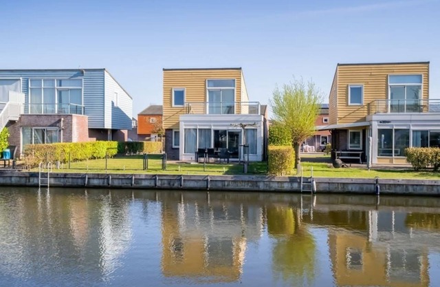 Island house with grass (play) field, green hedges and an open view.