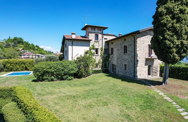 Luxurious villa surrounded by greenery with swimming pool and lake view