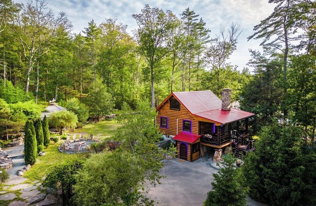 Private log cabin nestled at the base of a secluded wooded area n