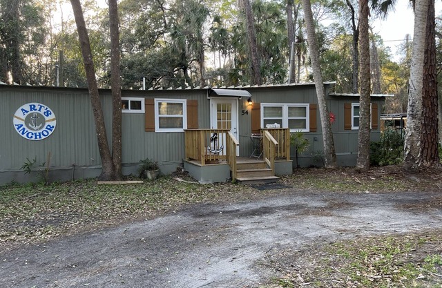 Step into this cozy 2-bedroom cabin nestled in the tranquil woods. The main living area offers comfy seating, including a pull-out futon for additional sleeping space. An efficiency kitchen awaits your culinary adventures, equipped with essentials fo