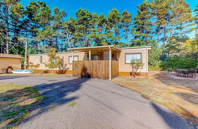 Tree-lined coastal home with children's items, gas grill, and washer/dryer