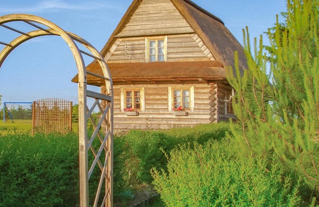 Year-round habitable wooden house with thatched roof.