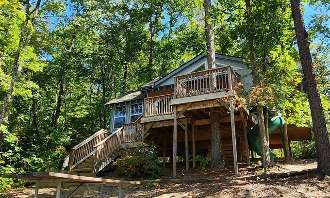 Mill Spring Cabin | 2-story treehouse with a cargo net connecting the upstairs lofts, a large balcony with a slide to the ground level, sleeps 10.