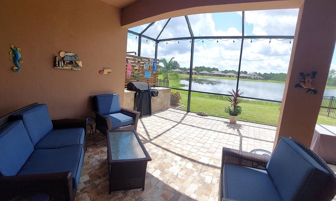 Port Malabar House | Lake view home with a screened outdoor entertainment area.